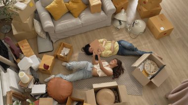 Genç bayan işyeri sahibi dükkanda dikilirken elinde karton tutuyordu. Teslimat ya da nakliye işlemleri için hazırlık yaparken paket ve kutu taşıyan çekici, mutlu girişimci. Myrmidon.