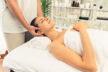 Kafkasyalı kadın stres önleyici kafa masajından ve lüks tatil beldesi ya da otel spa salonundaki modern ışık ortamında yüz güzelliği eğlencelerini şımartmaktan hoşlanıyor. Sessiz.