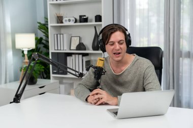 Sunucu kanalı, gülümseyen akıllı yayıncı kaydı, senaryosu ve akıllı telefonuyla sosyal medyada sohbet programı, kulaklık takarak modern ev stüdyosundaki video flamalarını kaydediyor. Bireysel.