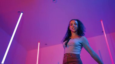 Latin dansçıların kameraya bakıp şehrin pop müziğiyle dans ettiği düşük açılı kamera. Profesyonel çekici hipster, mor veya neon ışıklı hip hop şarkısına geçiyor. Şık bir kumaş. Mutluluk.