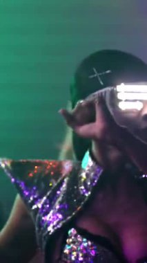 Bir grup insan disko gece kulübünde DJ 'in sahnede çaldığı müzikle dans ediyor. Yeni yıl partisi ve gece hayatı konsepti .