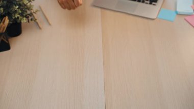 Şık bir ofis çalışma alanı modern bir dizüstü bilgisayar, kırtasiye malzemesi ve yatıştırıcı bir ev bitkisi sergiler. Temiz ahşap masa odaklanmış iş için davetkar bir atmosfer yaratır. SACTR