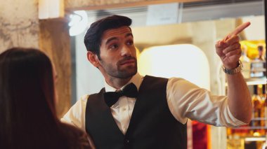 Gülümseyen zeki barmen, gece kulübünde VIP müşterilerle canlı sohbetler yapmak için güzel bir gece partisi atmosferine mükemmel bir servis sunuyor. Vinosity.