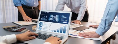 Masadaki bir grup iç mimar takımı dizüstü bilgisayarında mimari yazılım bulunan çeşitli ruh hali tahtası örneklerini seçiyor. Modern yenileme ve iç malzeme seçimi konsepti. İçgörü