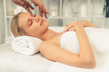 Kafkasyalı kadın stres önleyici kafa masajından ve lüks tatil beldesi ya da otel spa salonundaki modern ışık ortamında yüz güzelliği eğlencelerini şımartmaktan hoşlanıyor. Sessiz.
