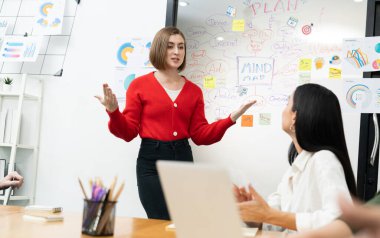 Profesyonel çekici kadın lider, modern iş toplantı odasında beyin fırtınası zihin haritalama istatistikleri ve renkli yapışkan notlar kullanarak yaratıcı pazarlama planını sunuyor. Tertemiz..