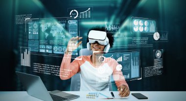 Masada kitap ve dizüstü bilgisayarla ödev yaparken metaevreleri birbirine bağlayan dizüstü bilgisayar ve artırılmış gözlük kullanan bir kız. Öğrenci holograma bakıyor ve yapay zekayı kullanıyor. Yaratıcılık.