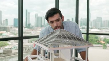 Modern ofiste gökdelen ve şehir manzaralı kalem ölçme modeli çatı uzunluğu kullanan profesyonel mimar mühendisi. Yetenekli proje yöneticisi ya da işadamı ev inşaatını kontrol ediyor. İzleme