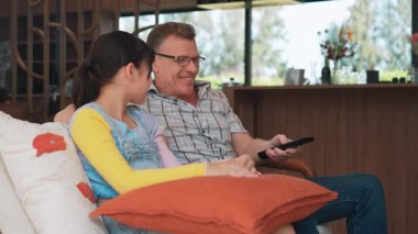 Büyükbaba ve torun birlikte TV 'de ilginç bir eğlence medyası izliyorlar. Eski üst düzey kullanım teknolojisi, genç nesil çapraz nesil ile iletişim kurarak aile bağlarını güçlendiriyor. Uyumsuzluk.