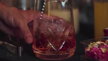 Yakın plan el yapımı barmen karışık alkollü likör şurubu karıştırıp buzla karıştırıyor. Barda eski moda kokteyl tatma kokteyli hazırlıyor ve gece hayatı karışımı sergiliyor. Vinosity.