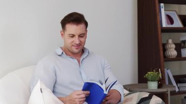 Kanepede oturan orta yaşlı bir adam, sosyal ve teknolojik mesleki gelişmeler hakkında ders kitabı okur ya da çocukları iyi bir yetişkin baba olmak için yetiştirir. Hayat boyu öğrenme konsepti. Uyumsuzluk.