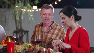 Yaşlı çift tatilini bahçede kutluyor. Emeklilik yaşlıları yemek yiyor. Rahatlamak, lezzetli yemekler yemek ve aile bağımızı güçlendirmek için dışarıda kamp yapmak. Uyumsuzluk.