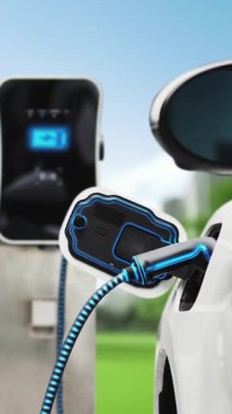 Yeşil Şehir Parkı 'ndaki ekolojik temiz enerji şarj istasyonundan gelen fütürist akıllı EV şarj aletinin şarj ettiği elektrikli araba. Alternatif enerji kullanan gelecekçi elektrikli araba. İnceleyin