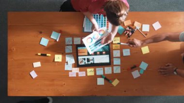 Web tasarımı için birlikte çalışan iş adamlarının üst düzey görüşü. Tasarımcı beyin fırtınası yapan ve web sitesi arayüzü hakkında tartışan ve dijital tasarım ile tablete bakan hava görüşü. Sempozyum.