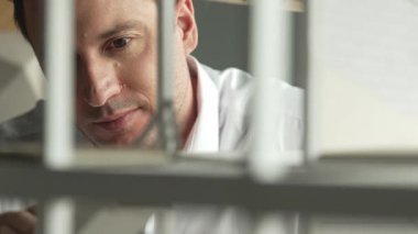 Kafkasyalı mimar mühendisinin yakın çekimi ev inşaatını denetlemek ve bina malzemelerini kontrol etmek. Proje yöneticisi modele dikkatlice bakarken kalemi işaret ediyor. Yönlendirici.