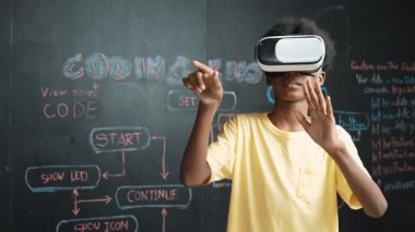 Genç ve güzel akademik öğrenci yazma, kodlama ve programlama sistemini bilgisayarı ya da aygıtı olan masaya yerleştirirken Afrikalı çocuk metaevrene girmek için kulaklık takıyor. yenilikçi eğitim. Öğretim