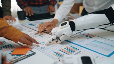 İnsan ve robot ellerin modern bir çalışma alanındaki veri raporları üzerinde işbirliği yaparak takım çalışması ve iş analizlerinde yaratıcı problem çözme sahnesi. Noogenesis