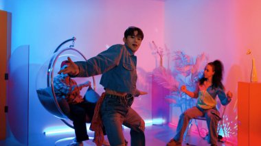 Çok kültürlü bir arkadaş kürsüde otururken Asyalı yetenekli bir dansçı modern müziğe geçiyor. Profesyonel dansçı, hipster takımı tezahürat yaparken ve desteklerken enerjik adımlar atıyor. Mutluluk.