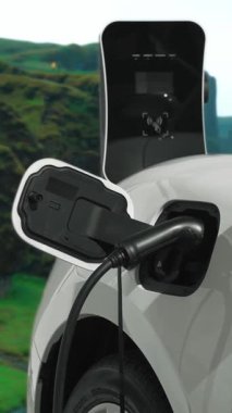 Elektro jeneratör sürücüsüyle enerji sürdürülebilir araba gücü, şarj istasyonunda şarj edilen batarya, ilerici seyahat konsepti için dağ zeminine sahip. Temiz ortamın sembolü olarak doğadaki EV otomobil.
