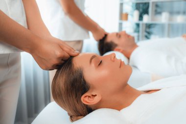 Kafkasyalı çift stres önleyici kafa masajının keyfini çıkarıyor ve lüks otellerde ya da otel spa salonlarında gündüz kaplıcalarında yüz güzelliği eğlencelerini şımartıyor. Sessiz.