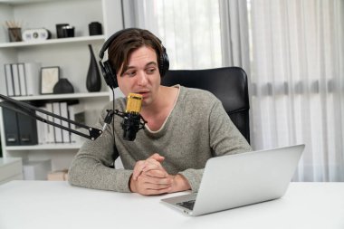 Sunucu kanalı, gülümseyen akıllı yayıncı kaydı, senaryosu ve akıllı telefonuyla sosyal medyada sohbet programı, kulaklık takarak modern ev stüdyosundaki video flamalarını kaydediyor. Bireysel.