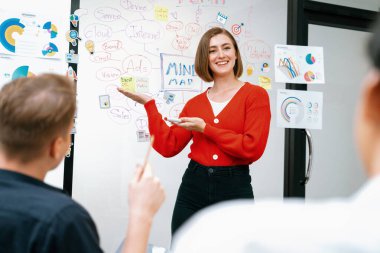 Erkek proje yöneticisinin yakın plan görüntüsü soru sormak için el kaldırırken, genç güzel lider zihin haritası ve renkli yapışkan notlar kullanarak iş projesini kendinden emin bir şekilde sunuyor. Tertemiz..