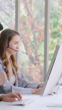 Ofiste çalışan kulaklık takan işadamları uzak müşteri ya da meslektaşlarını desteklemek için çalışıyorlar. Arama merkezi, tele pazarlama, müşteri destek acentesi telefon görüşmesinde hizmet sunar.