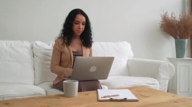 İnternette önemli bir iş için dizüstü bilgisayar kullanan Afro-Amerikalı bir kadın. Evde çalışan sekreter veya çevrimiçi içerik yazma.