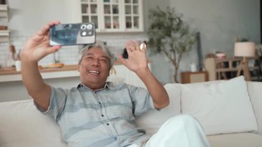 Mutlu büyükbaba elinde akıllı bir telefonla yeğenini arıyor ve evdeki kanepede oturuyor. Son sınıf öğrencisi, iletişim kurmak için cep telefonunu çalıştırırken oğluna selam veriyor. Bağlanma konsepti. Myrmidon.