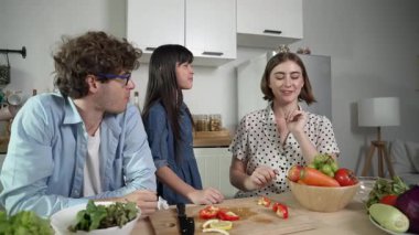 Çekici beyaz anne ve baba Asyalı kızıyla taze yemek pişirmek için birlikte vakit geçiriyorlar. Annem ve babam mutfakta salata yapmak ve sebze yemek için taze sebze hazırlıyorlar. Pedagoji.