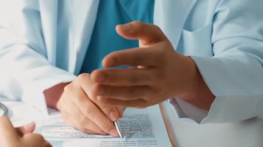 Hastanedeki doktor masasında oturup hasta test sonuçlarını teşhis eden, hastalıklar ve hastalıklar için tedavi planı geliştiren evrak işleriyle uğraşıyor. Sağlık personeli ve sağlık hizmetleri. Ağır çekim. Katı.