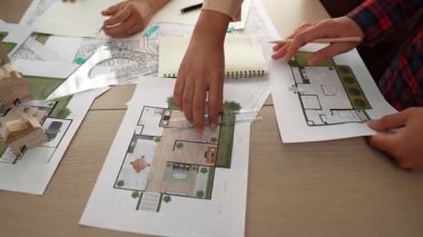 Akıllı mimar ya da akıllı mühendisin ölçüm aracı ve kalem el kullanarak mimari ofisindeki inşaat isabet planı üzerine detaylı bir yazı yazışının videosu. Eline odaklan. - Yakın çekim. Tanımlama.