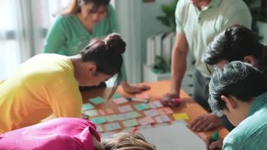 Beyin fırtınası yapmak için zihin haritasını kullanarak geliştirici ekibi kapatın. Kaliteli iş adamlarının üst düzey görüşü, kalemler ve yapışkan notlar kullanarak birlikte pazarlama stratejisi yazmalarıdır. Sempozyum.