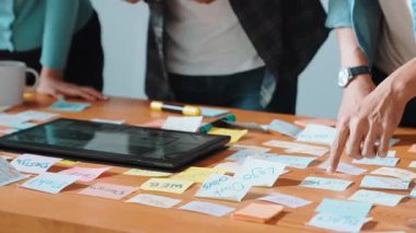 Dizüstü bilgisayara bakan ve logo tasarımını işaret eden yetenekli bir iş ekibi ana tema rengini seçme ve pazarlama kampanyasını planlama kararı alıyor. Birlikte çalışan akıllı bir grup. Sempozyum.