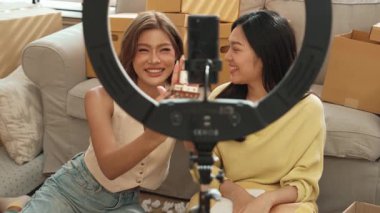 Kadın girişimci çevrimiçi pazarlama platformu kullanarak ürünü sunmaya başlarken çevrimiçi canlı yayın platformunda insanları selamlıyor. Çekici satıcı ya da etkili kayıt videosu. Myrmidon.