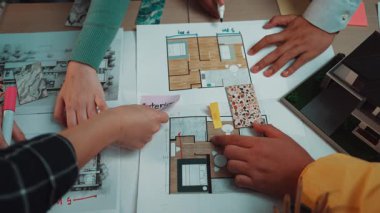 İç mimaride işbirlikçi tasarım planlaması sergilenen dinamik bir sahne, mimari taslaklar üzerinde taslak çizim ve tartışmalar yapan eller. SACTR