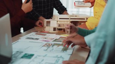 Çeşitli mimarlardan oluşan bir grup aktif olarak bir ofiste işbirliği yaparak modelleri ve planları gözden geçirir. Fikirler değişirken atmosfer yaratıcılığı ve yeniliği yansıtıyor. SACTR