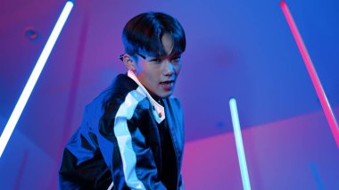 Profesyonel sokak dansçısının sıradan kıyafetlerle kameraya baktığı alçak açılı kamera. Stüdyoda mor ışık altında dururken şehirde pop müzik yapan yetenekli bir sanatçı. Kapatın. Mutluluk.