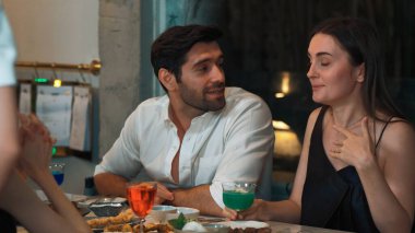 Birkaç arkadaş renkli karışık kokteyller içerken garsonlar da yemek masasında özel bir partiyi kutlamak için yemek ve içecekler lezzetlidir. Vinosity.