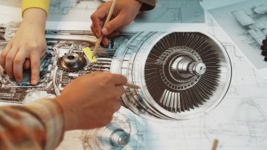 Bir jet motorunun detaylı teknik çizimlerini havacılık tasarım ortamında bileşenler ve takım çalışmalarına odaklanarak analiz eden ellerin yakın çekim görüntüsü. SACTR