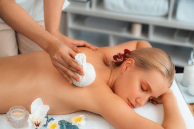 Sıcak bitkisel top spa masaj vücut tedavisi, masör kadın vücuduna nazikçe şifalı bitki torbası bastırıyor. Aromaterapi dinlenme sükuneti ve sükuneti kaplıca salonundaki atmosferi aydınlatıyor. Sessiz.