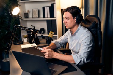 Akıllı yayıncının sunucu kanalı, canlı sosyal medyada canlı yayında konuşma programı ile birlikte modern stüdyoda, kayıt cihazıyla dinleyiciye senaryo okumaktadır. Bireysel.