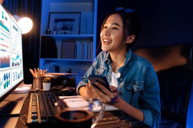 Gülümseyen genç, güzel Asyalı yaratıcı satış hedefi raporunun kar tablosuna bakıyor ve notlar üzerine notlar yazarak neon ışığı gecesinde yeni bir strateji pazarı projesine yatırım yapmayı planlıyor. Taktik.