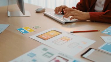 Mobil uygulama için kullanıcı arayüzü prototipini ofis çalışma alanındaki akıllı yöneticiye sunan mükemmel bir şirket çalışanı. UX UI tasarımcısı kağıt üzerinde simge tasarımının işlevini açıklıyor. Sinerjik