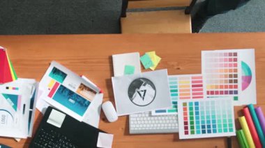 Kulaklıktan müzik dinlerken yetenekli iç dizayn grafiklerinin yukarıdan aşağı havadan görüntüsü. Proje yöneticisi kulaklıkla çalışırken ve rahat şarkılar dinlerken stüdyoda hareket ediyor. Sempozyum.