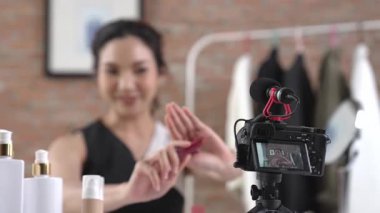 Kadın nüfuzlu kişi canlı yayın yapan video görüntülerini sosyal medya ya da blog üzerinden gözden geçiriyor. Kozmetik stüdyosu ışıklandırmalı mutlu genç kız çevrimiçi pazarlama oturumu yayını için..