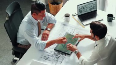 Proje planının dizüstü bilgisayarında ev inşaatı ve ekipmanlarıyla toplantı masasında oturup plan yazarken yöneticilerin konuşmalarının ve ev inşaatı hakkında tartışmalarının en üst görüntüsü. Hizalama.