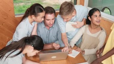 Kafkas öğretmenler dersi dizüstü bilgisayar kullanarak öğretirken öğrencilerin en üst görüşü soru sorar. Zeki eğitmen etrafını dinleyen ve ders veren çeşitli öğrencilerle çevrili olan projeyi açıklıyor. Öğretim