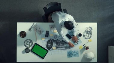 Ekipman ve elektronik jeneratörle toplantı masasında otururken, yetenekli mühendis yazma ve planlama motoru tasarımının en alt görüntüsü. Teknisyen not alıyor. Hizalama.