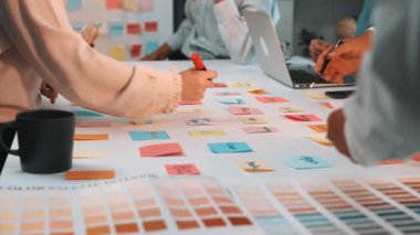 Canlı ve bağlı bir profesyonel grup, yaratıcılık ve üretkenliği artırmak için yapışkan notlar ve dijital araçlar kullanan modern bir çalışma alanında işbirliği yapıyor. SACTR